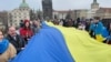 Украинцы разворачивают флаг своей страны на Карловом мосту в Праге. Чехия, 19 января 2025 года 