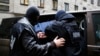 The Internal Security Agency (ABW) officers escort a man arrested on suspicion of spying