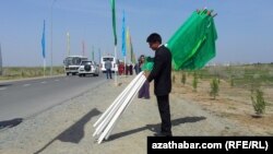 Работник собирает флаги на публичном мероприятии в Ашхабаде, фото 2015 года 
