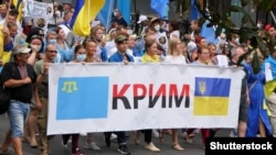 Шествие в Киеве с флагом крымских татар и украинским флагом